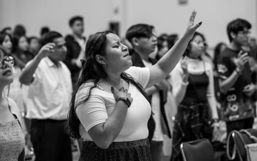 A large group of individuals engaged in prayer during a religious gathering in Mexico City.