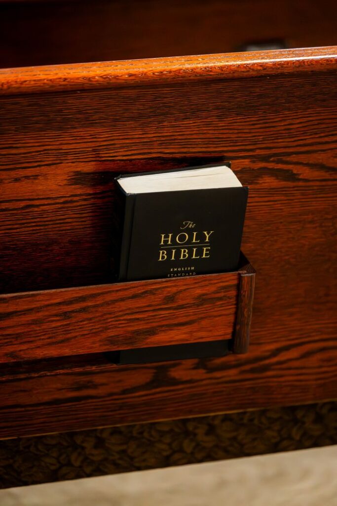 A Holy Bible resting in a church pew holder, symbolizing faith and spirituality.